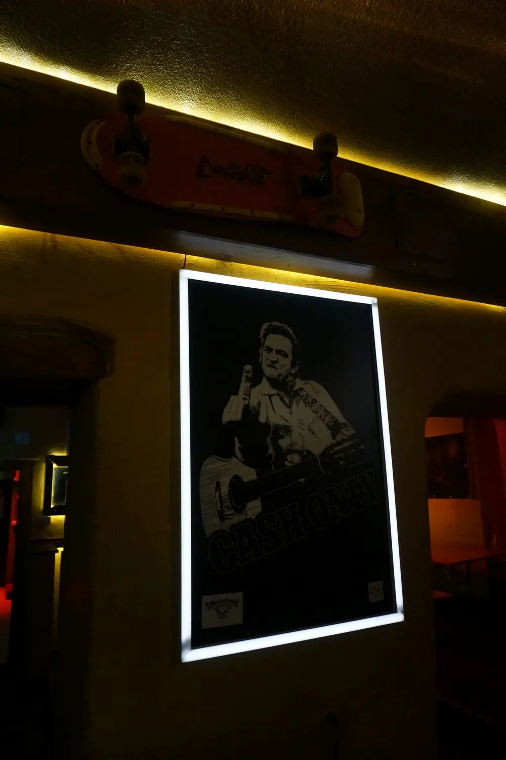 The lit Johnny Cash poster on the wall