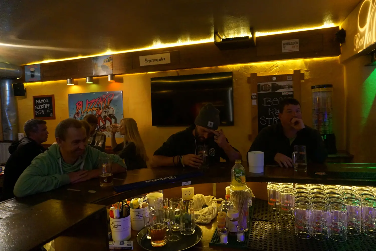 Guests sit at the counter in front of the chalkboard and a band poster