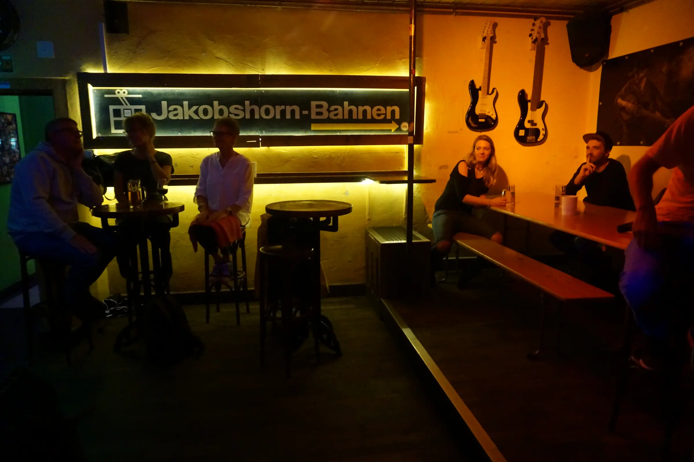 Guests at high tables and on the bench under the sign of the Jakobshorn cable car