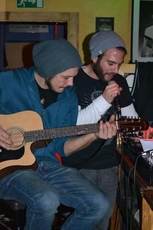 Two musicians with guitar and microphone at an Open Mic session