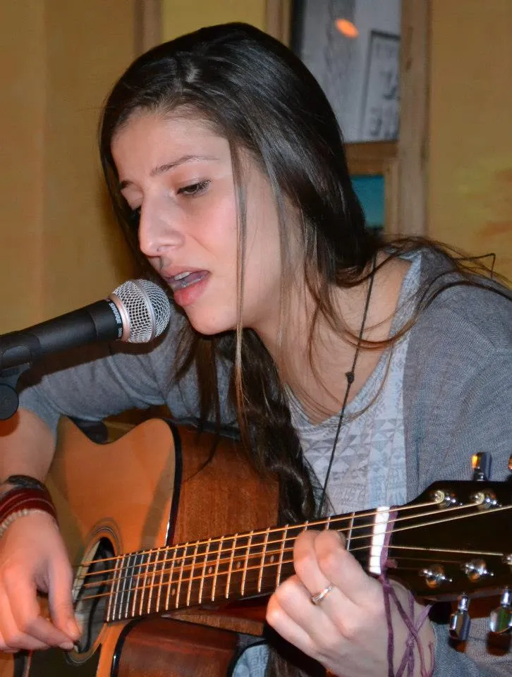 A singer plays guitar and sings into the microphone