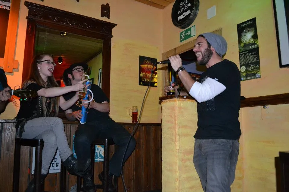 Guests sing along, one stands with the microphone in front of the counter
