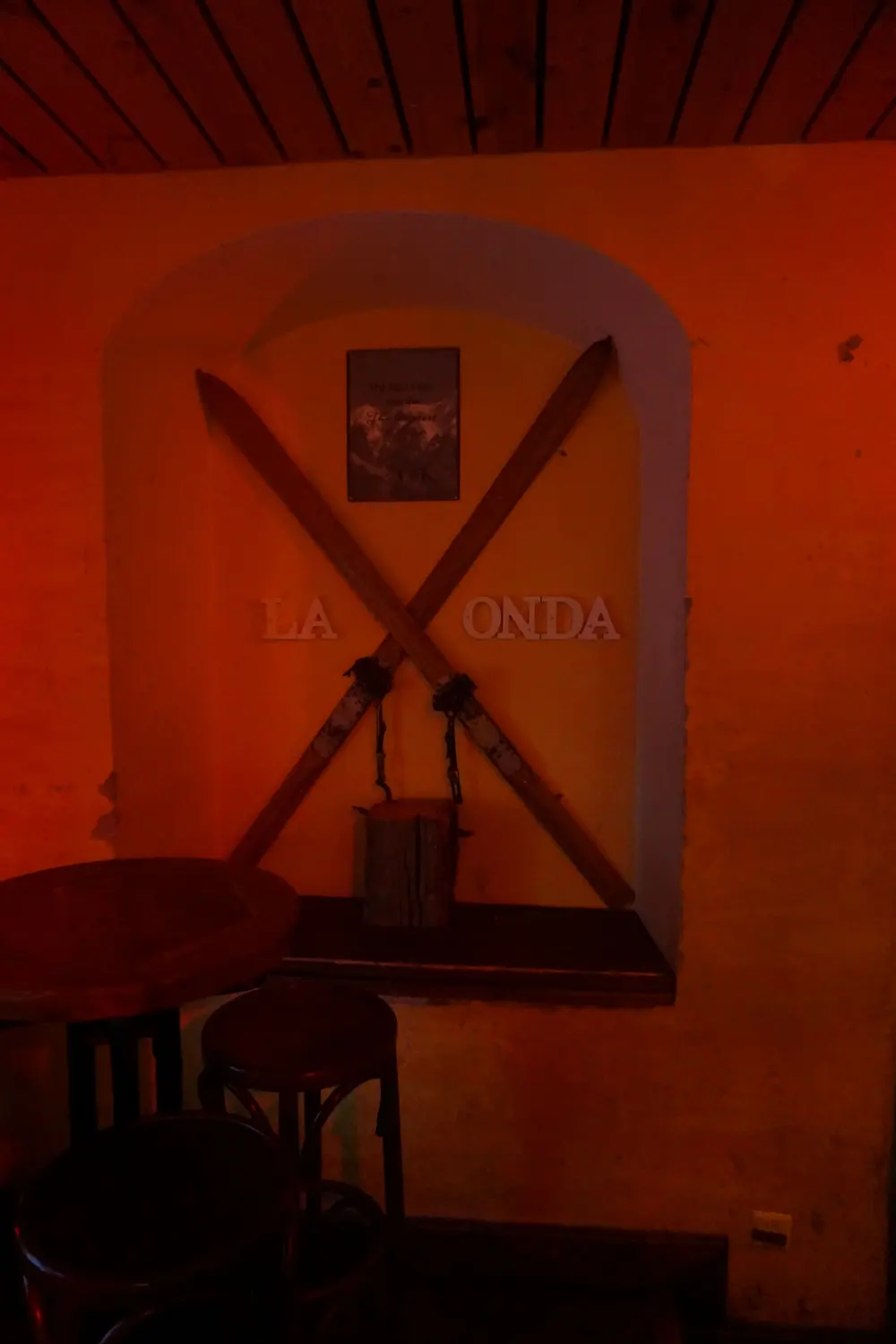 Two crossed old wooden skis on the wall, the lettering La Onda between them