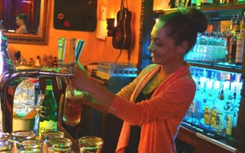 Gloria pours a beer at the counter of Bar LaOnda
