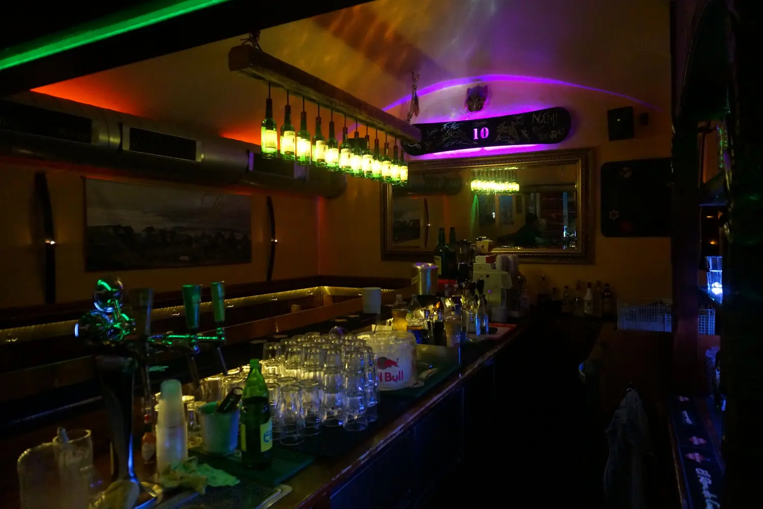 The long counter with glasses under the bottle lamps