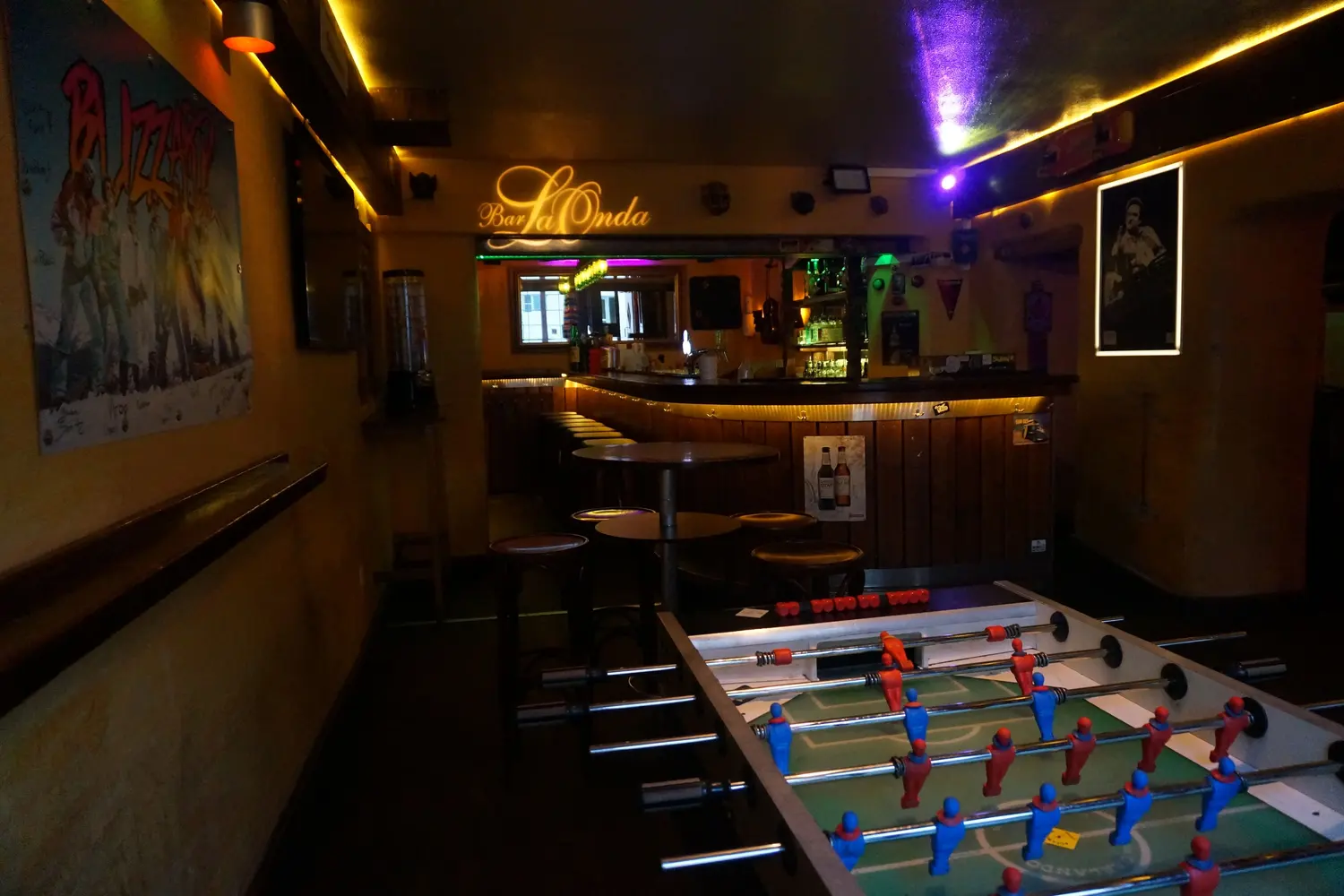 The table football with red and blue players in front, behind it high tables and the lit wooden counter with the Bar LaOnda lettering